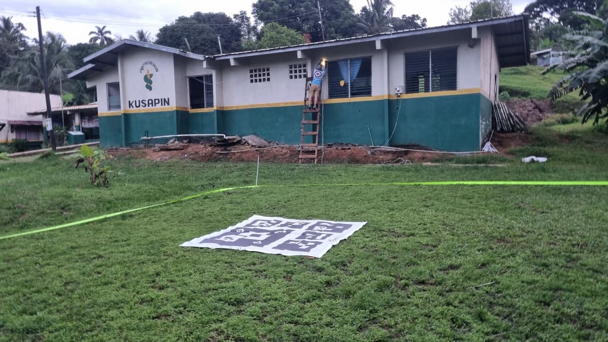 Zona de aterrizaje delimitada frente al centro de salud de Kusapín, mientras un técnico instala equipos en la fachada