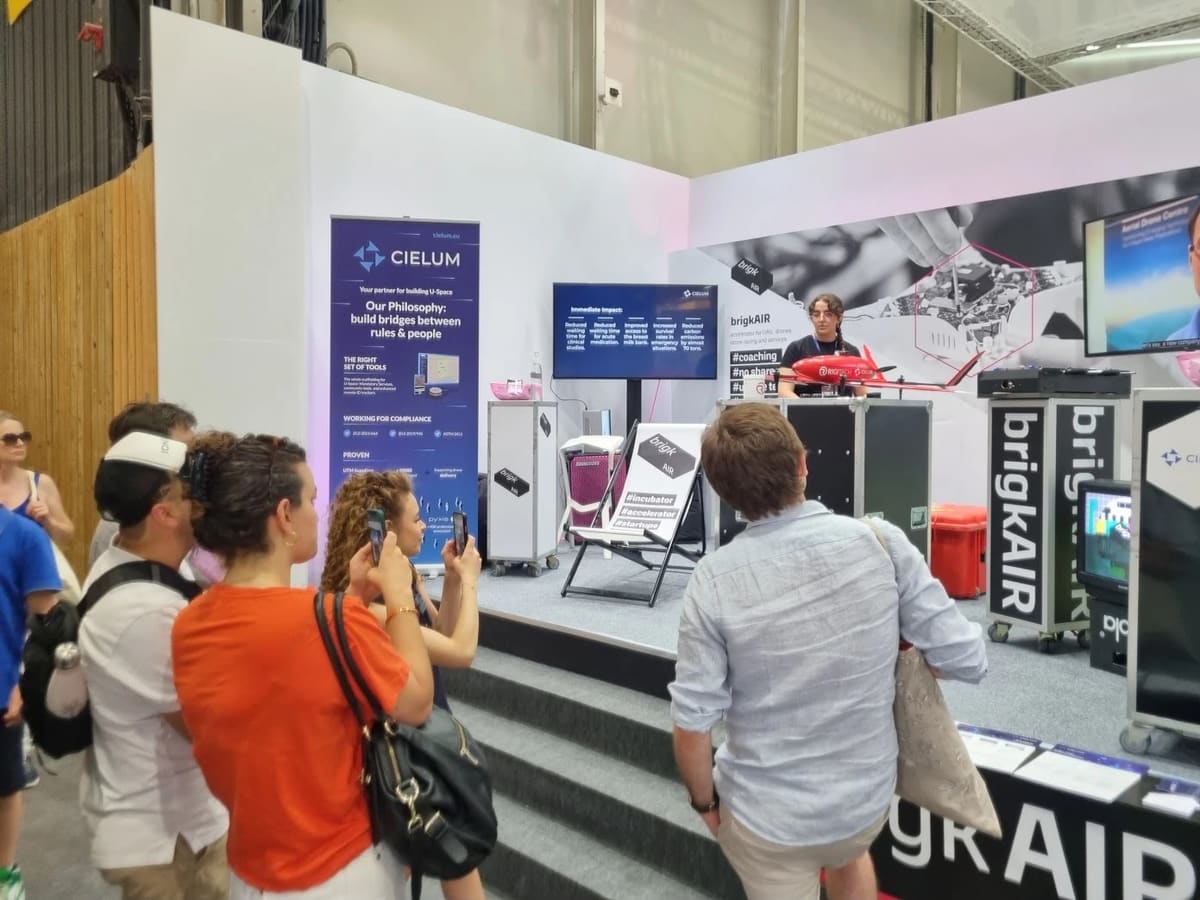 Stand de brigkAIR en el Paris Air Show con el banner de CIELUM, una pantalla con el impacto del proyecto y una aeronave RigiTech
