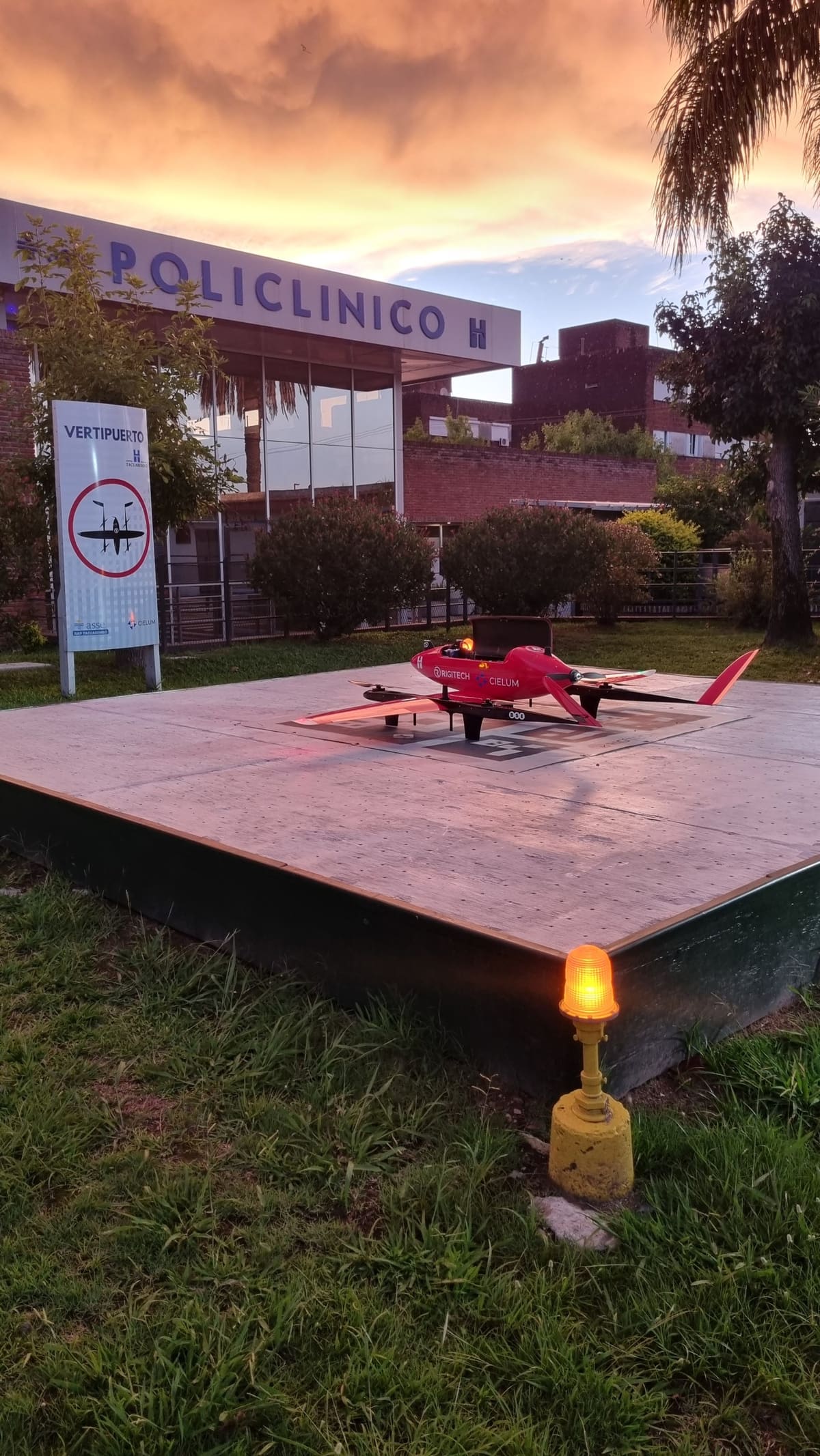 Aeronave sobre el vertipuerto de un policlínico al atardecer